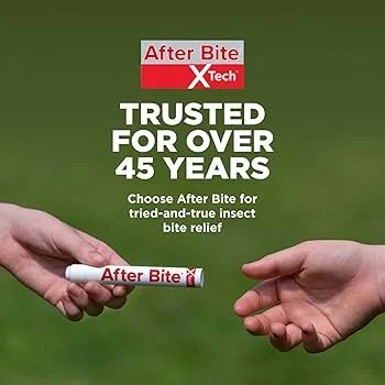 Two hands, one holding a small tube of After Bite X Tech, the other with an open hand, outdoors with a green background.